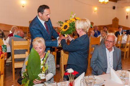 Sekretarz Miasta Wisła Sylwester Foltyn wręcza kwiaty jubilatom